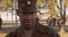 a man wearing glasses and a military uniform with the letter x on it