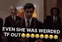 a man in a suit and tie stands in front of a group of men and says even she was weirded