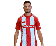 a man wearing a red and white stoiximan shirt