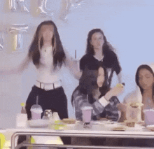 a group of people are sitting at a table eating food and drinking .