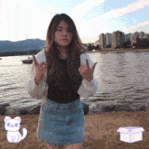 a woman standing in front of a body of water