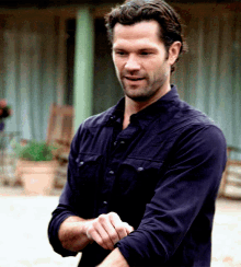 a man in a black shirt is smiling and looking at something