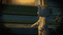 a baby with a pacifier is crawling next to a teddy bear .