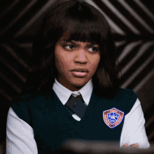 a girl in a school uniform has a badge on her vest that says ' brooklyn college ' on it