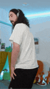 a man with long hair is wearing headphones and a white shirt