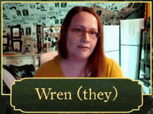 a woman wearing glasses is behind a sign that says wren ( they)