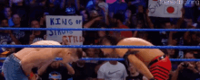 two wrestlers in a ring with a sign that says king of style