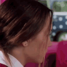 a close up of a woman 's face with a ponytail .