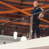 a police officer stands on a balcony holding a bag