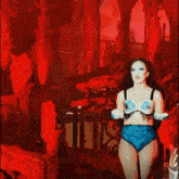 a woman in a blue bra and high waisted shorts is dancing on stage