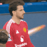 a soccer player wearing a red shirt that says snapdgo on it