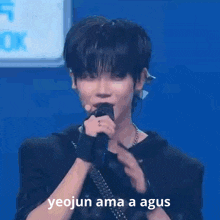 a young man singing into a microphone with the words yeojun ama a agus written on the bottom