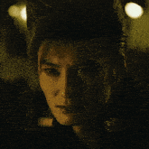 a close up of a man 's face with his hair in a ponytail
