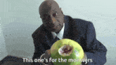 a man in a suit and tie is holding a globe with the words this one 's for the monsters on the bottom