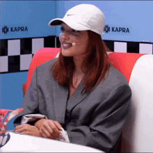 a woman with red hair wearing a white nike hat