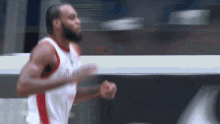 a basketball player in a red and white uniform is running on the court .