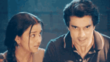 a man and a woman are looking at each other with a serious look on their faces