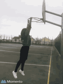 a person is playing basketball on a court with a momento logo in the corner