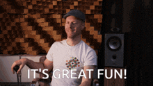 a man sitting in front of a speaker with the words it 's great fun below him