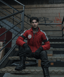 a man wearing a red jacket that says globe oil sits on stairs