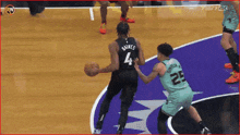 a basketball player with the number 4 on his back dribbles the ball