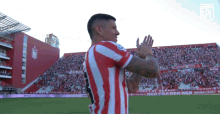 a man wearing a red and white striped shirt with the number 8 on the back