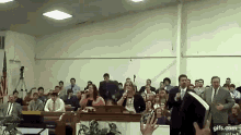 a group of people singing in a church with gifs.com at the bottom of the screen