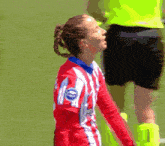 a female soccer player wearing a red and white jersey with a blue patch on the back that says ' fc ' on it