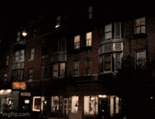 a blurry picture of a building at night with imgflip.com on the bottom