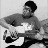 a man wearing a vans off the wall shirt playing a guitar