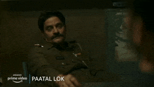 a man in a police uniform is talking to another man in a black shirt .