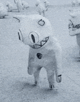 a black and white photo of a statue of a cat with a smile on its face