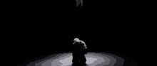a man is kneeling down in the dark .