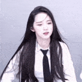 a girl with long black hair is wearing a white shirt and tie