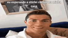 a man is sitting on a couch with a caption that says " eu esperando a shirlei chegar na minha casa "