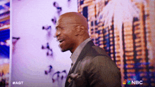 a man stands in front of a screen that says nbc on it