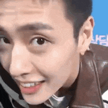 a close up of a man 's face wearing a leather jacket .