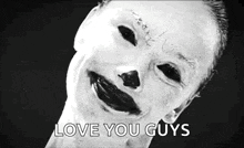 a black and white photo of a child with a clown face and the words `` love you guys '' written below it .