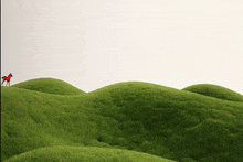 a red horse on top of a green hill