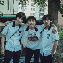 three young men in school uniforms are posing for a picture together .