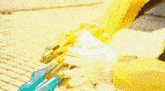 a close up of a person 's arm with a yellow and blue weapon .