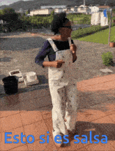 a woman in overalls is dancing with the words esto si es salsa written below her