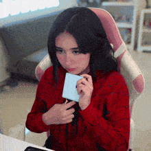 a girl in a spiderman costume is holding a white box in front of her face