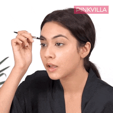 a woman applying makeup with a pinkvilla logo in the background