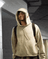 a man wearing a hoodie and headphones has a backpack