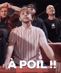 a man in a striped shirt is sitting in front of a group of people and says a poil