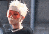 a woman with blonde hair wearing red sunglasses