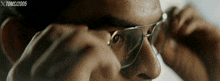 a close up of a man wearing glasses with the year 2005 on the bottom left