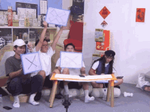 a group of people are sitting around a table holding up signs that have x and y on them