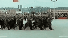 a large group of soldiers marching down a street .